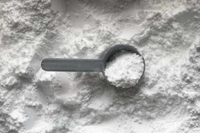 Poudre blanche de créatine monohydrate et doseur